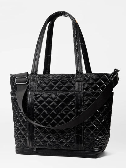 The MZ Wallace Large Empire Tote in Black Liquid Oxford is a stylish black quilted nylon tote bag featuring two short handles and an adjustable shoulder strap, making it perfect for those who love lightweight crossbody bags against a plain background.