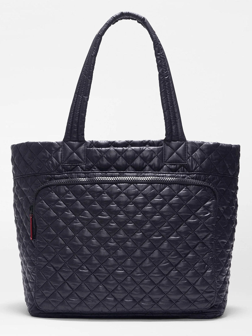 The MZ Wallace Large Metro Travel Tote in Black Oxford, featuring double handles, Italian leather trim, and a front zippered pocket, is displayed against a plain white backdrop.