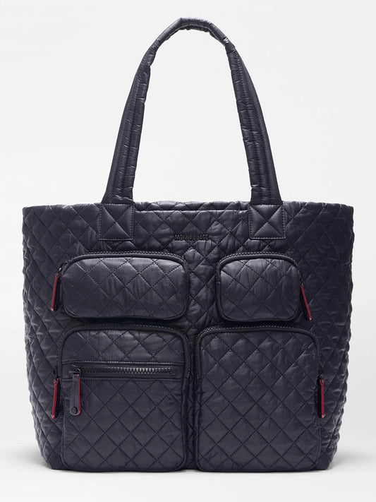 The MZ Wallace Large Metro Travel Tote in Black Oxford features a quilted design, Italian leather trim, two top handles, and four front zip pockets with red pulls—ideal as a stylish laptop bag.