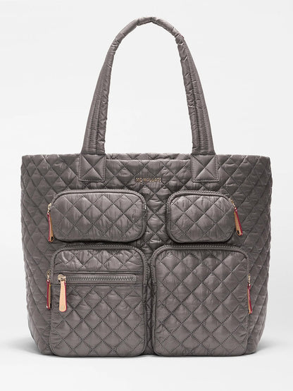 The MZ Wallace Large Metro Travel Tote in Magnet Oxford features durable quilted Oxford fabric, four front zippered pockets, and two shoulder straps, shown against a plain white background.