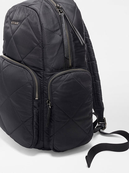 A close-up of the MZ Wallace Madison Backpack in Black Bedford, featuring quilted design, multiple zippered compartments, adjustable straps, and a convenient luggage sleeve for travel.