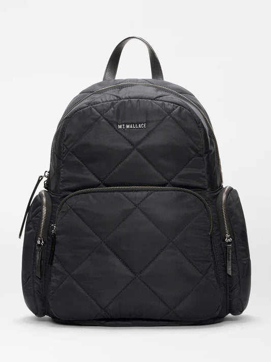 The MZ Wallace Madison Backpack in Black Bedford features a quilted design with multiple zippered compartments, top handle, adjustable straps, a luggage sleeve, and displays the MZ Wallace logo on the front.