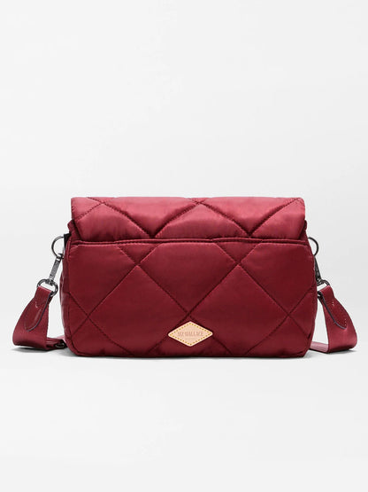The MZ Wallace Madison Flap Crossbody in Claret Bedford is a chic, quilted maroon bag crafted from recycled Bedford nylon. It features a diamond pattern, adjustable strap, and a small tan logo patch on the front—perfectly combining sustainability with everyday elegance.