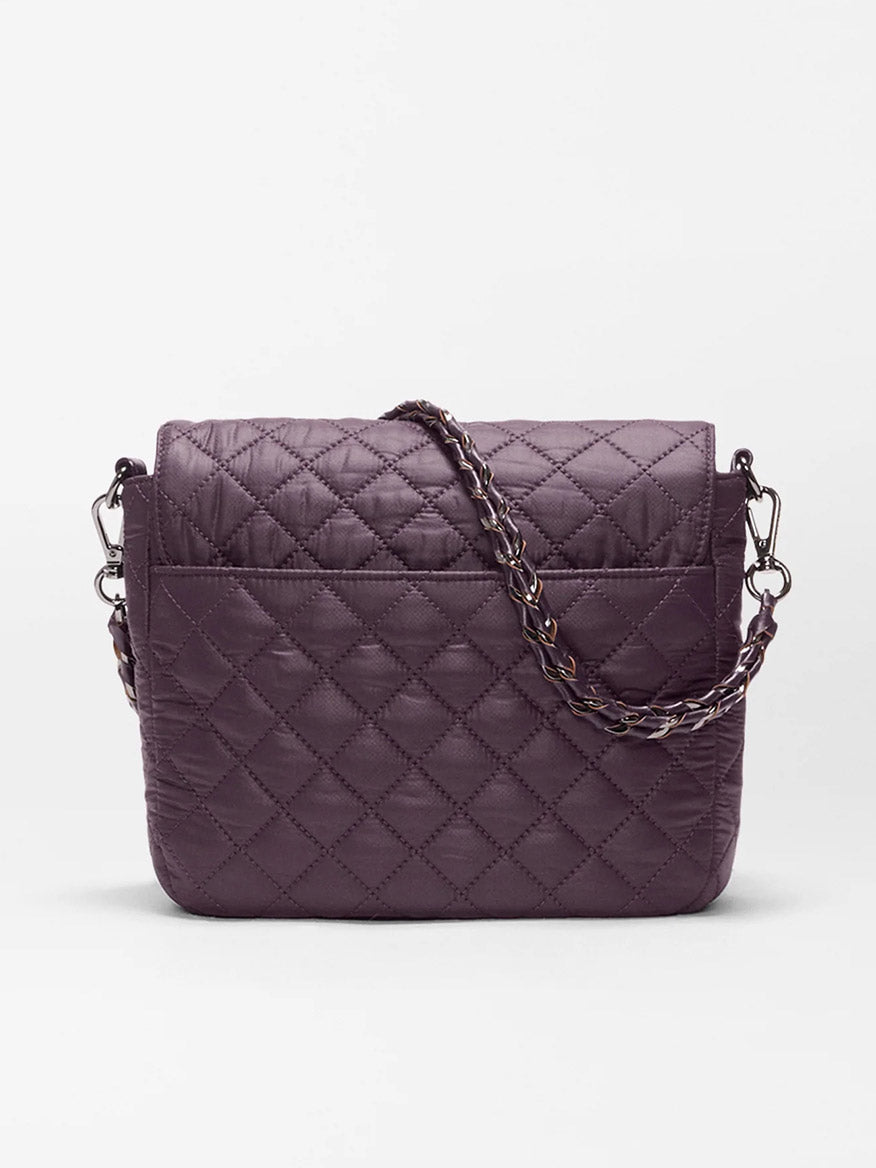 The MZ Wallace Crosby Lock Medium Crossbody in Raisin Oxford is a quilted, purple recycled nylon handbag featuring a flap closure and metal chain strap, elegantly accented with luxurious Italian leather trim, displayed against a plain white background.