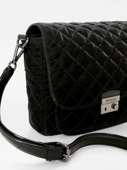 Black quilted MZ Wallace Crosby Lock Medium Crossbody bag in a velvet finish with metal lock hardware and an adjustable shoulder strap.