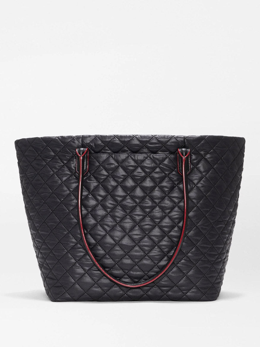 The MZ Wallace Medium Daily Tote in Black Oxford is a stylish, black quilted tote bag with a diamond stitching pattern and slim shoulder straps accented in red, expertly crafted from recycled nylon. This chic laptop-friendly tote is shown against a plain white background.