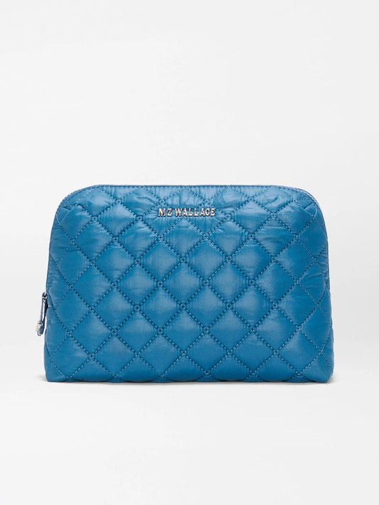 The MZ Wallace Medium Double Zip Cosmetic in Atlantic Blue Oxford is a quilted pouch bag made from recycled nylon, featuring zippered side openings perfect for organizing travel essentials, and is finished with the “MZ WALLACE” label on the front, displayed against a plain light background.