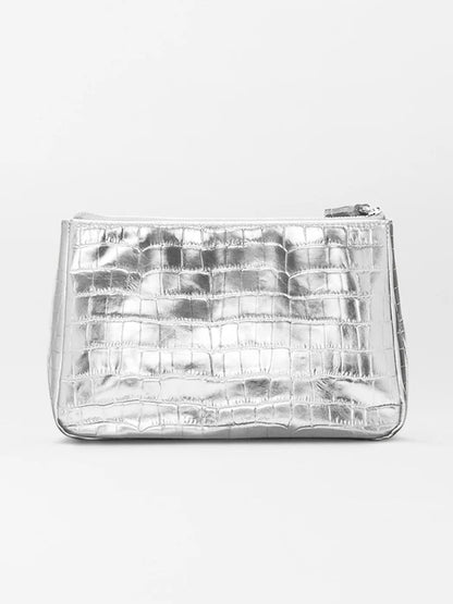 The MZ Wallace Medium Luna Cosmetic in Silver Croc Effect is a rectangular metallic silver leather bag with a crocodile texture and zip-top closure, set against a plain light background.