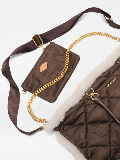 The MZ Wallace Medium Madison E-W Tote in Shearling & Walnut features quilted nylon with white trim, gold chain detail, a matching crossbody strap, and a small brown zip pouch with gold zipper and logo patch.