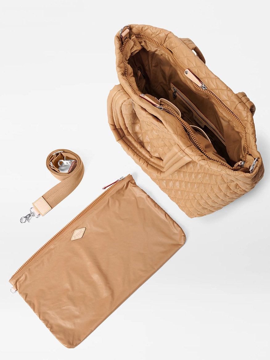 A caramel quilted Medium Metro Tote Deluxe by MZ Wallace with various compartments, Italian leather trim, a detachable shoulder strap, and matching zippered pouch on a white background.