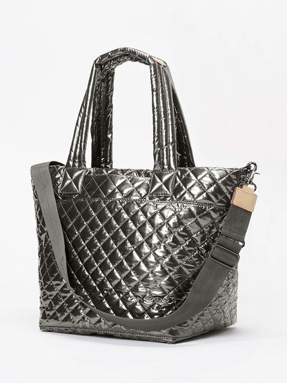 The MZ Wallace Medium Metro Tote Deluxe in Pewter Metallic Oxford showcases a quilted metallic design with dual handles and an adjustable shoulder strap. This versatile bag also features a removable crossbody strap and a convenient luggage sleeve for seamless travel.