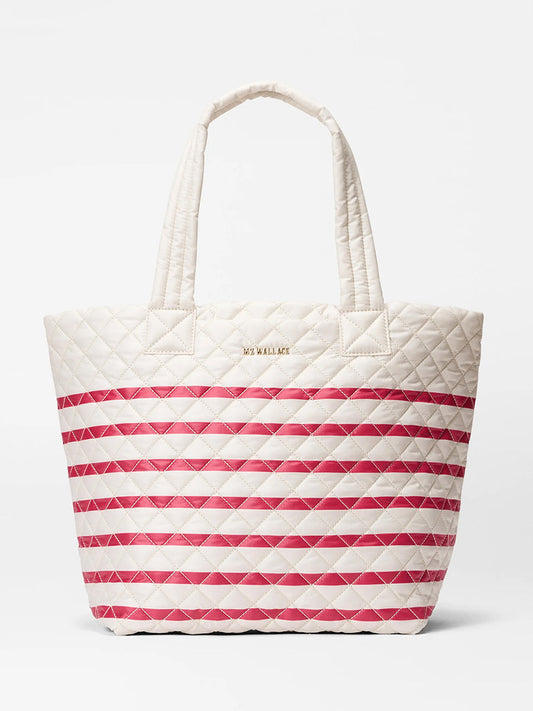 The MZ Wallace Medium Metro Tote Deluxe in Sandshell/Apple Charter Stripe Oxford features a white quilted design with red stripes, two handles, gold "MZ WALLACE" logo, and a luggage sleeve for easy travel.