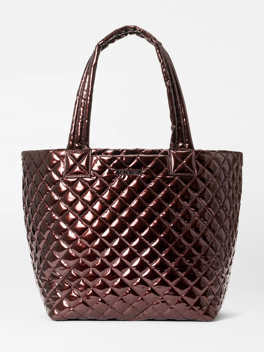The MZ Wallace Medium Metro Tote Deluxe in Bordeaux Lacquer Oxford features a shiny quilted diamond pattern, two handles, and is shown against a white background—ideal for stylish travel.