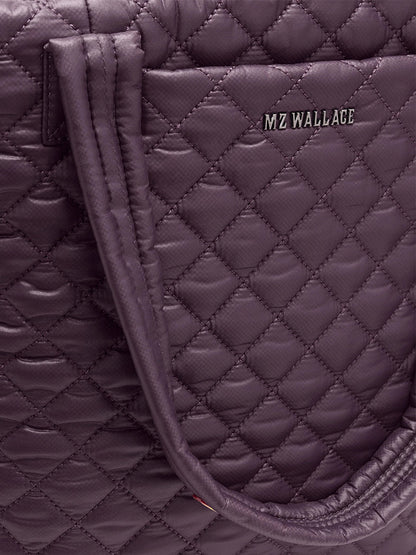 Close-up of the MZ Wallace Medium Metro Tote Deluxe in Raisin Oxford, featuring double handles, front "MZ WALLACE" branding, and a quilted featherlight design that highlights its chic style.