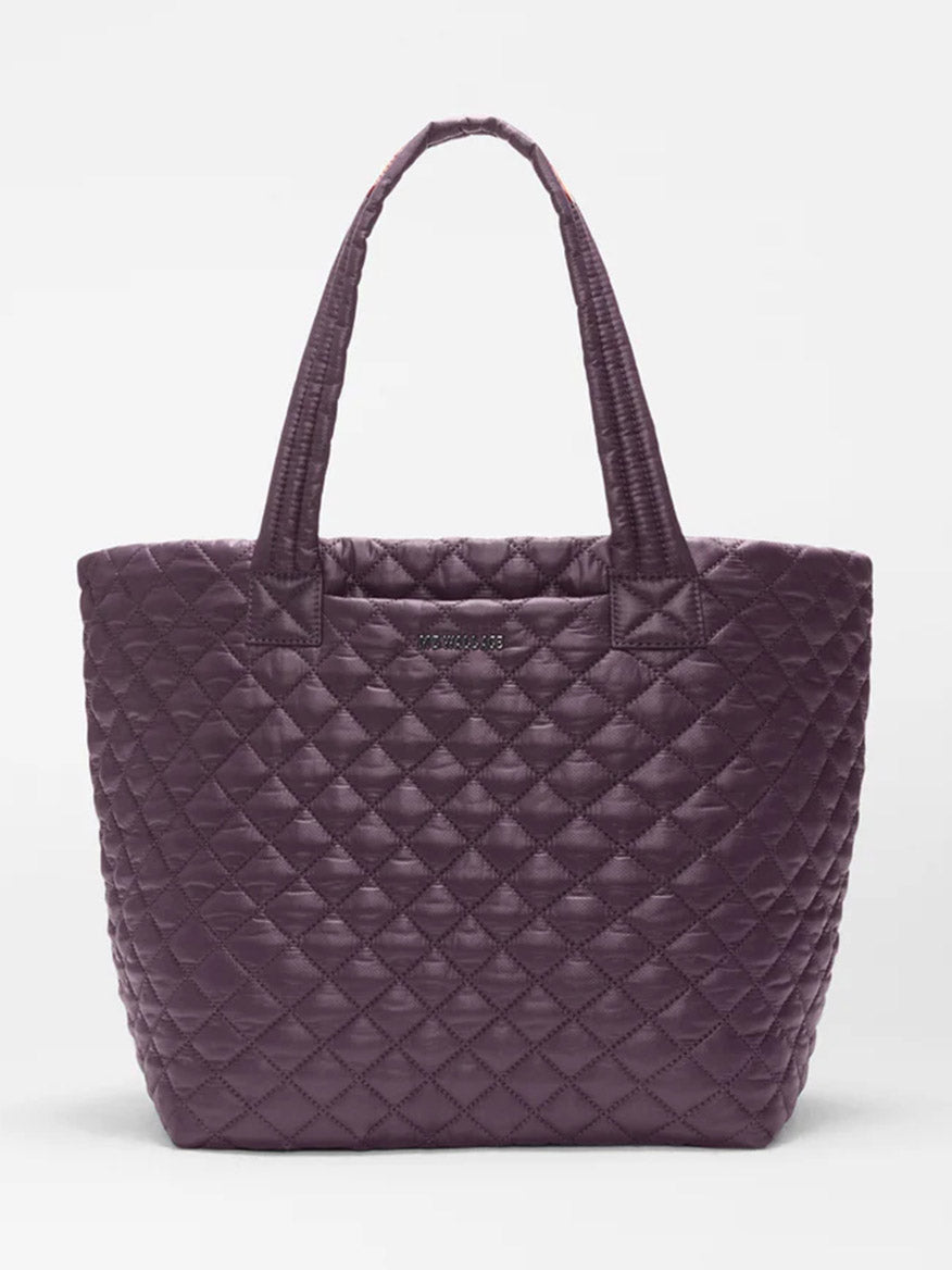 The MZ Wallace Medium Metro Tote Deluxe in Raisin Oxford features a diamond-quilted design, two handles, and a featherlight feel, shown here against a plain white background.
