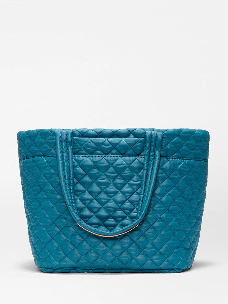 The MZ Wallace Medium Metro Tote Deluxe in Pacific Oxford is a teal, featherlight quilted bag with double handles, shown against a plain white background.