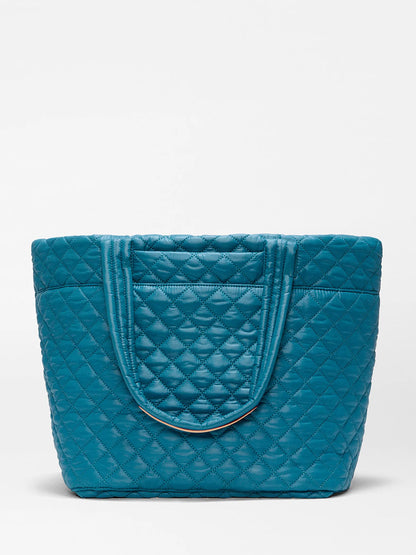 The MZ Wallace Medium Metro Tote Deluxe in Pacific Oxford is a teal, featherlight quilted bag with double handles, shown against a plain white background.