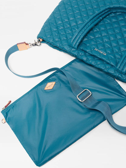 The MZ Wallace Medium Metro Tote Deluxe in Pacific Oxford, a teal featherlight bag with handles and a detachable strap, is shown with a matching flat pouch on a white surface—perfect as your go-to tote.
