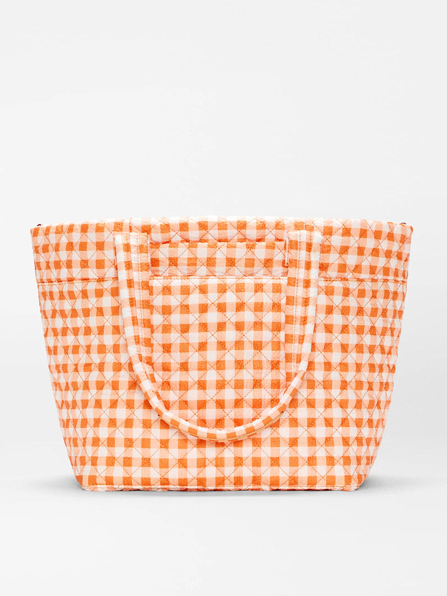 The MZ Wallace Medium Metro Tote Deluxe in Sunset Orange Gingham Oxford features quilted recycled nylon, two handles, and is ideal for work or travel. Shown against a plain white background.