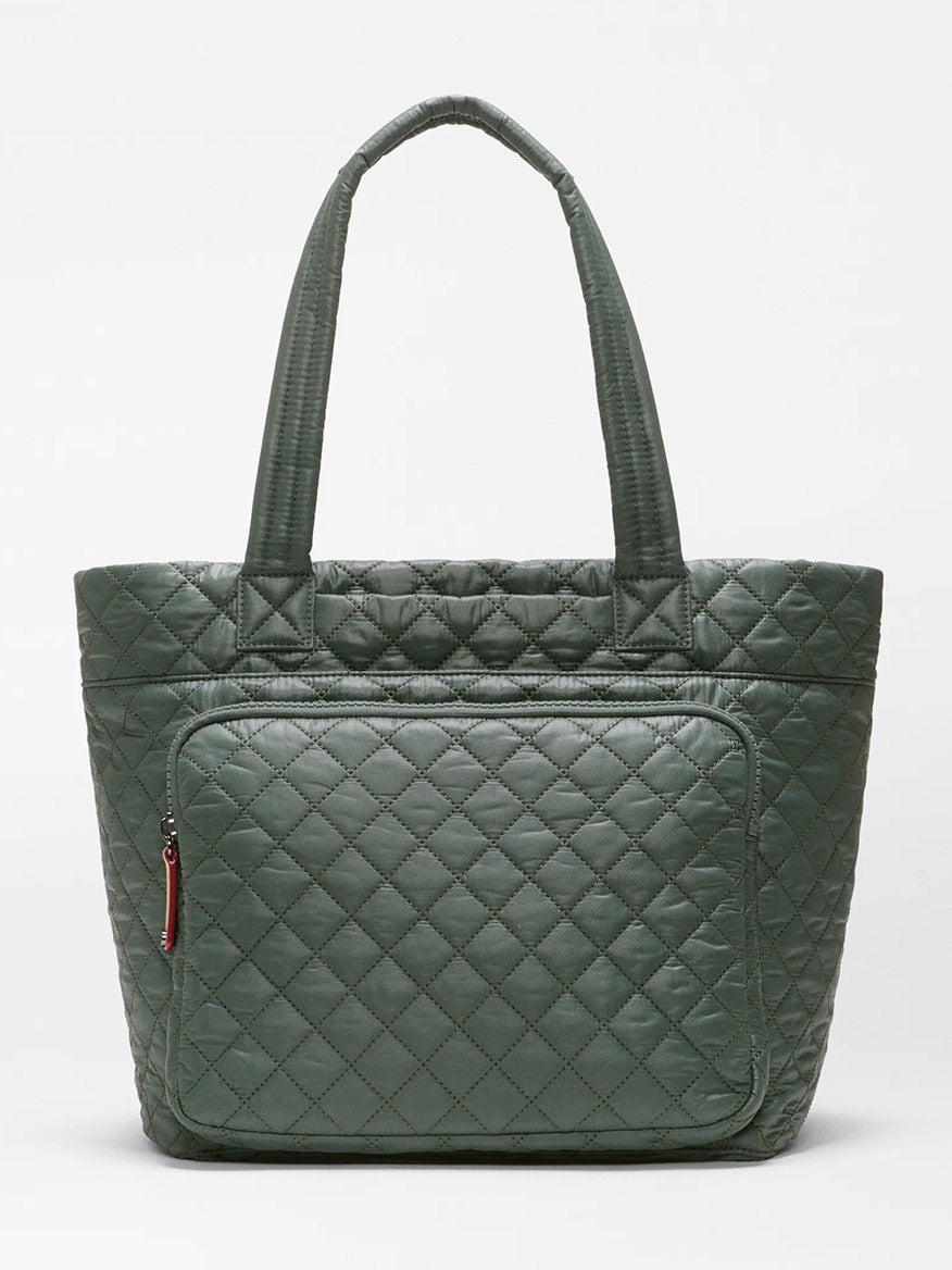 The MZ Wallace Medium Metro Travel Tote in Juniper Oxford is a green quilted recycled Oxford nylon bag featuring two handles and a front zippered pocket, displayed against a plain white background.