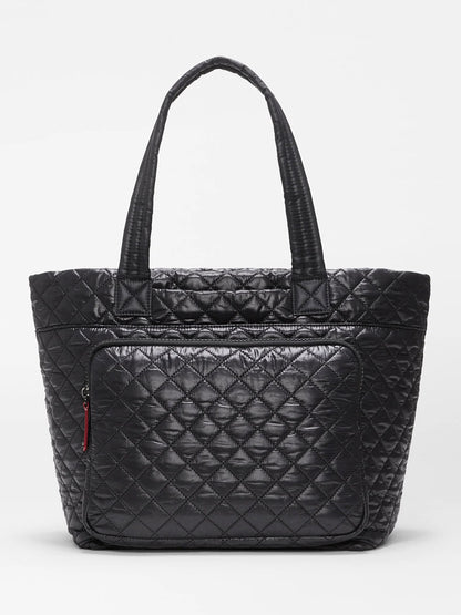 MZ Wallace Medium Metro Travel Tote in Black Oxford—crafted with a quilted design, two handles, and a front zippered pocket—shown against a plain white background; the ideal tote for work and travel.