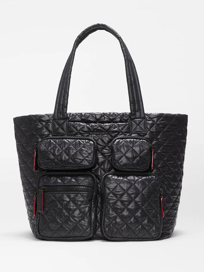 MZ Wallace Medium Metro Travel Tote in Black Oxford—this black quilted tote features two top handles and four front zippered pockets with distinctive red zipper pulls, all crafted from durable black nylon and shown against a plain white background, making it the perfect travel organizer bag.