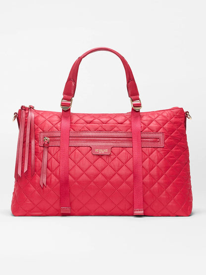 The MZ Wallace Medium Park Satchel in Apple Oxford is a quilted bright pink everyday bag with dual handles, a front zipper pocket, and decorative tassels, shown against a plain white background.