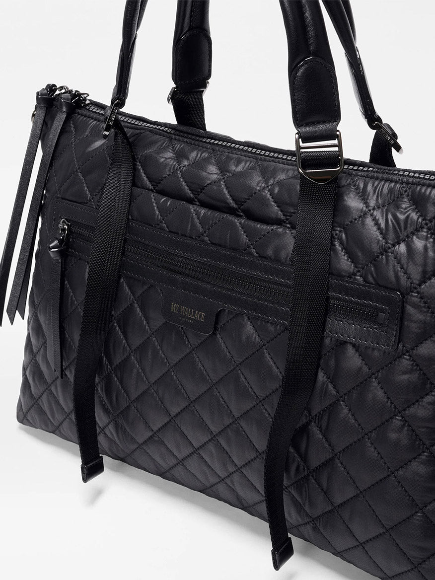 The MZ Wallace Medium Park Satchel in Black Oxford features dual handles, a front zip pocket, and a visible "MZ WALLACE" label—making it the perfect everyday quilted shoulder bag.