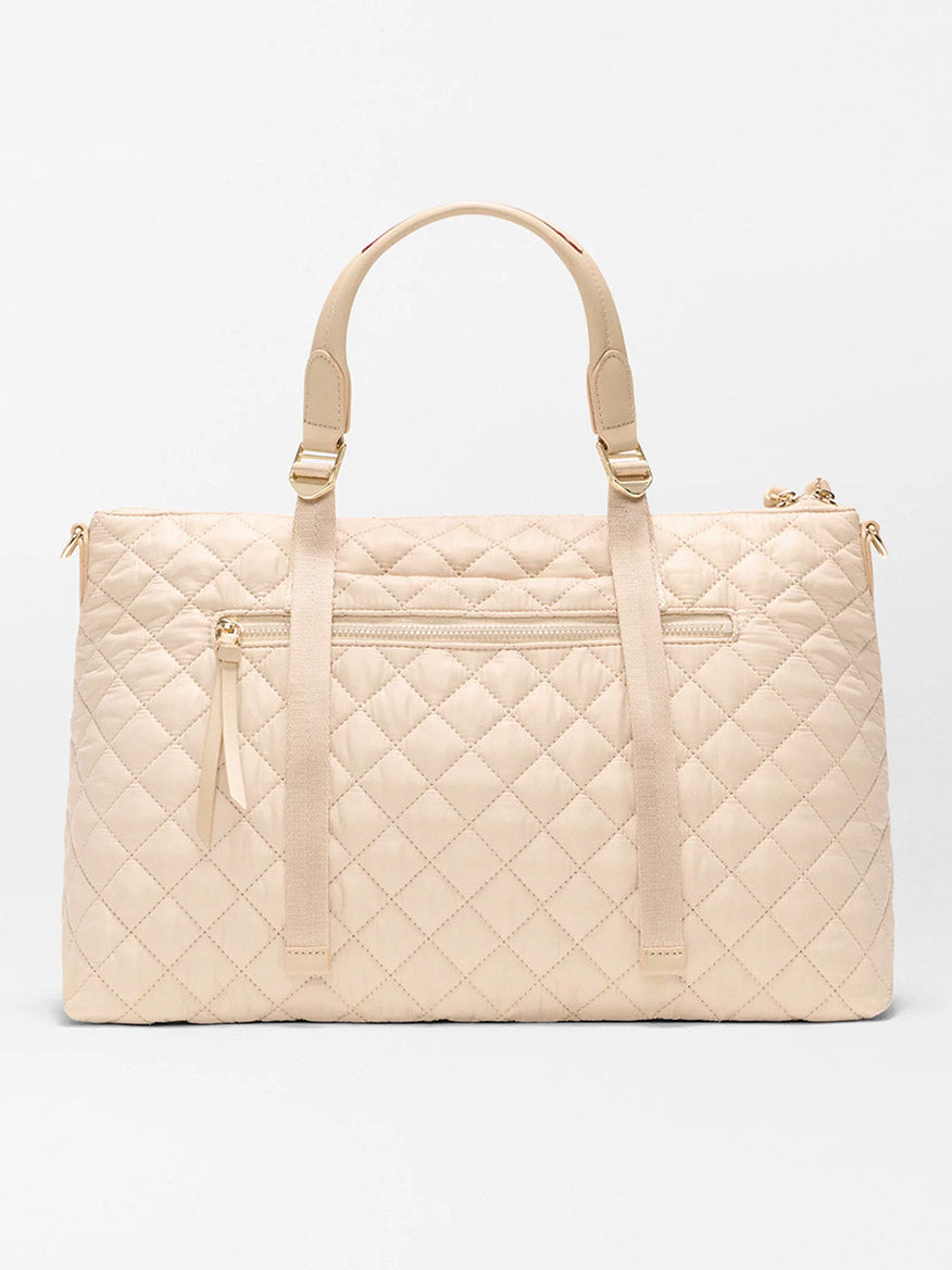 The MZ Wallace Medium Park Satchel in Buff Oxford features a beige quilted design, two top handles, a front zip pocket, and gold-tone hardware—ideal for everyday use—shown against a plain white background.