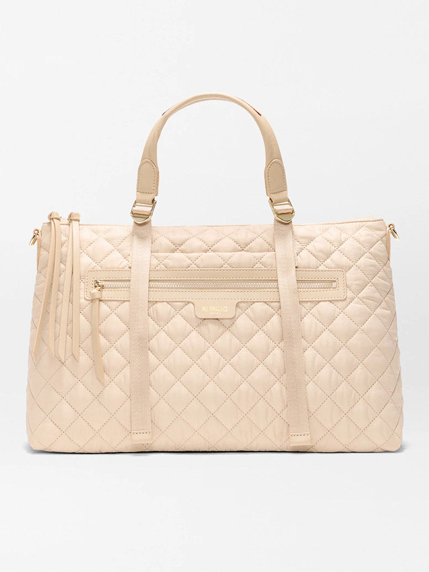 The MZ Wallace Medium Park Satchel in Buff Oxford, featuring quilted leather, two top handles, a front zip pocket, and tassels, is an ideal everyday bag—shown here against a plain white background.