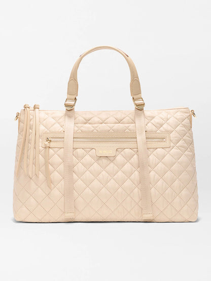 The MZ Wallace Medium Park Satchel in Buff Oxford, featuring quilted leather, two top handles, a front zip pocket, and tassels, is an ideal everyday bag—shown here against a plain white background.