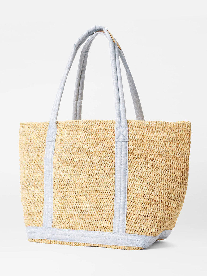 A large summer tote bag made from sustainably sourced Raffia, accented with light gray fabric handles and trim, placed against a plain white background.
