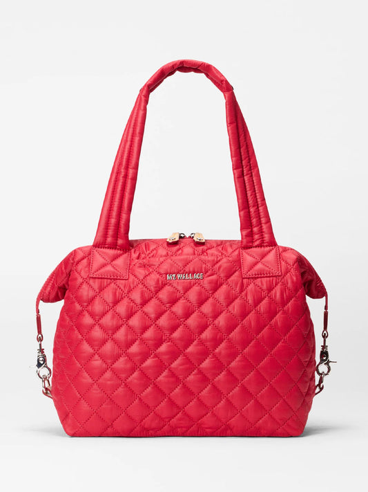 The MZ Wallace Medium Sutton Deluxe in Apple Oxford is a red quilted tote with two handles, silver hardware, a front metal logo, and a roomy interior for essentials. Shown against a plain white background.