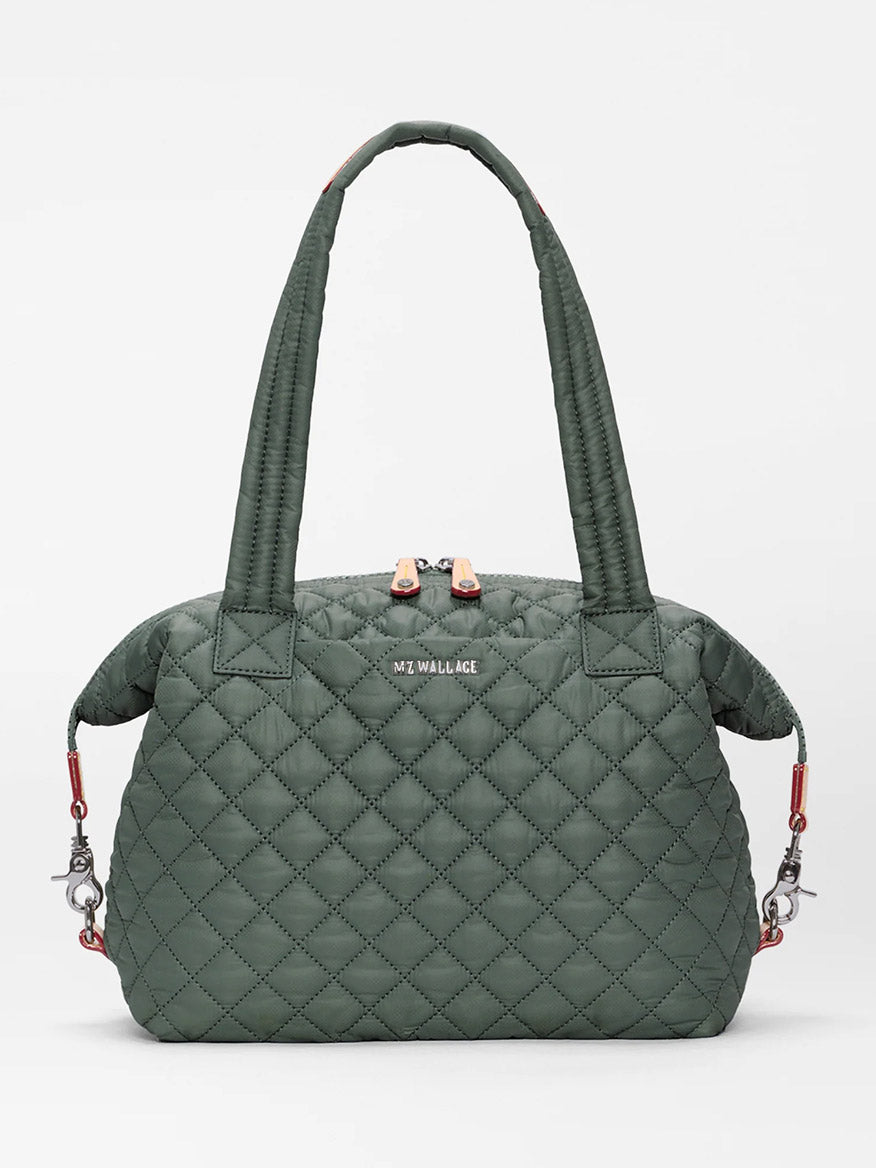 The MZ Wallace Medium Sutton Deluxe in Juniper Oxford is a green quilted handbag featuring two handles, a zip closure, and silver hardware. Crafted from recycled Oxford nylon for a structured carry, it is displayed against a plain white background.