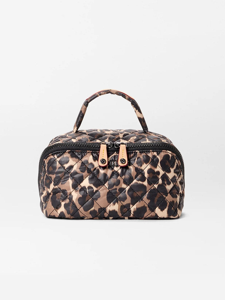 The MZ Wallace Metro Accordion Cosmetic II in Leopard Oxford is a small, rectangular quilted bag with a leopard print, oxford fabric, top handle, dual gold zipper pulls, and interior pockets, shown on a plain white background.