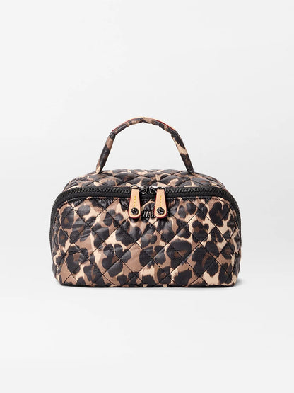 The MZ Wallace Metro Accordion Cosmetic II in Leopard Oxford is a small, rectangular quilted bag with a leopard print, oxford fabric, top handle, dual gold zipper pulls, and interior pockets, shown on a plain white background.