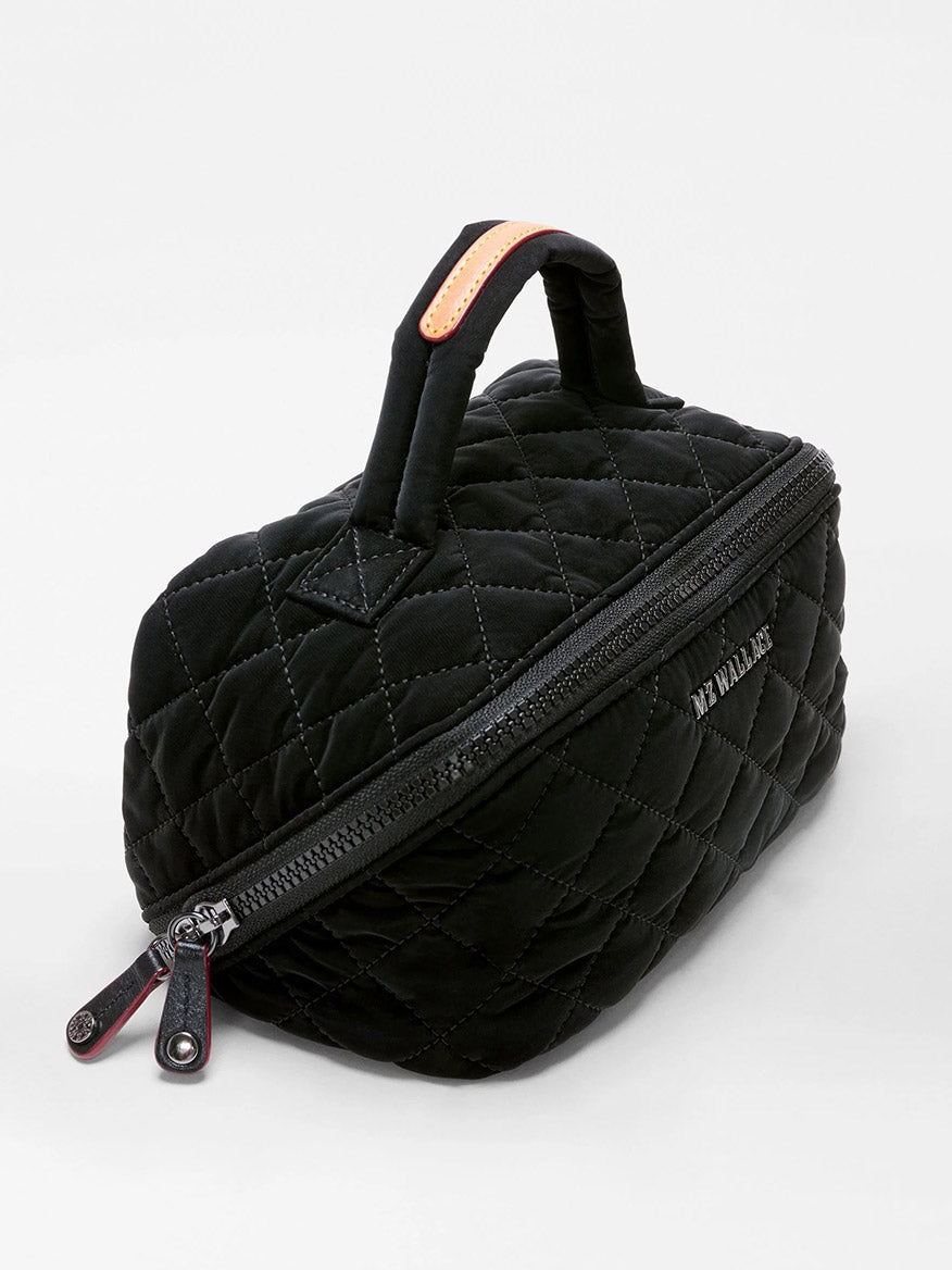 Presenting the MZ Wallace Metro Accordion Cosmetic II in Black Velvet Finish—a black quilted bag with a handle, angled zipper closure, and “MY WALLET” text on the side, elevated by sophisticated Italian leather trim, beautifully showcased against a plain white background.