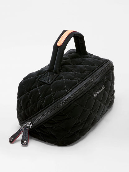 Presenting the MZ Wallace Metro Accordion Cosmetic II in Black Velvet Finish—a black quilted bag with a handle, angled zipper closure, and “MY WALLET” text on the side, elevated by sophisticated Italian leather trim, beautifully showcased against a plain white background.