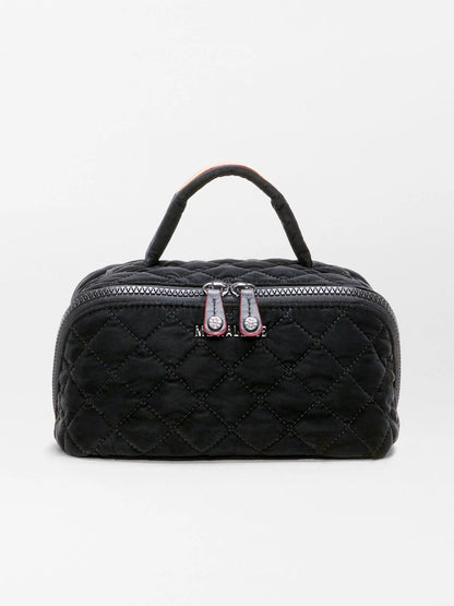 The MZ Wallace Metro Accordion Cosmetic II in Black Velvet Finish is a small black quilted fabric bag featuring a luxurious black velvet finish, silver zippers, Italian leather trim, and a short handle, shown against a plain white background.