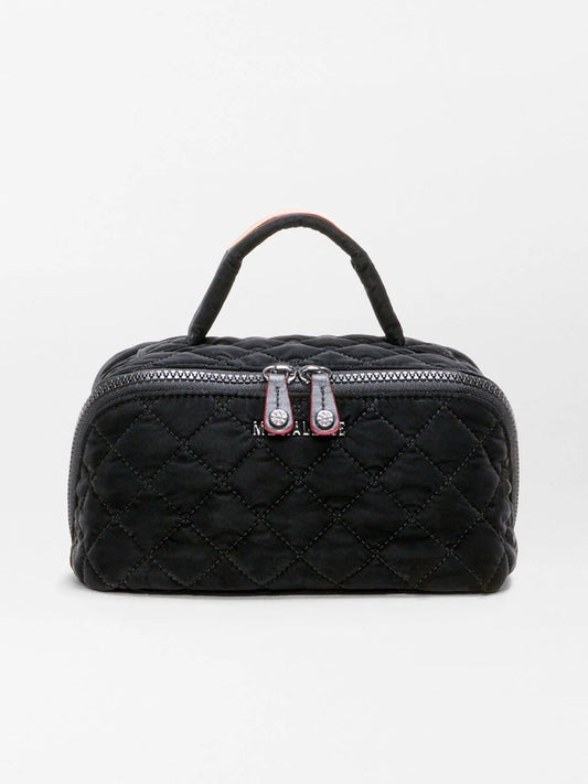 The MZ Wallace Metro Accordion Cosmetic II in Black Velvet Finish is a small black quilted fabric bag featuring a luxurious black velvet finish, silver zippers, Italian leather trim, and a short handle, shown against a plain white background.