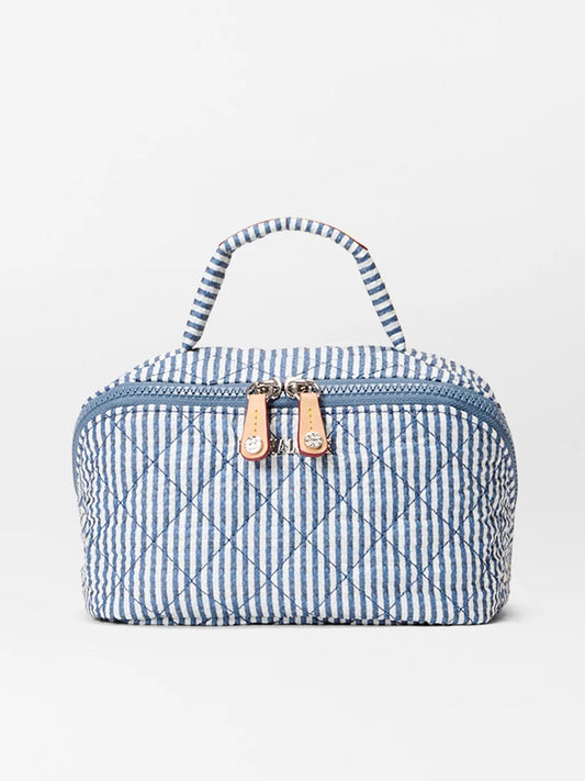 The MZ Wallace Metro Accordion Cosmetic in Seersucker Oxford is a blue and white striped quilted nylon bag with a top handle and dual front zipper pulls, ideal for keeping your essentials organized while traveling.