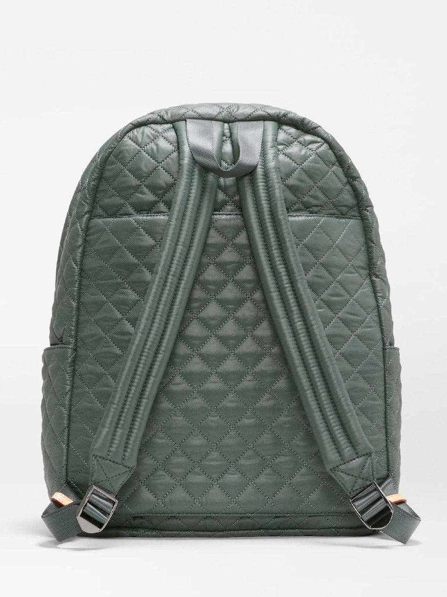 The MZ Wallace Metro Backpack II in Juniper Oxford is showcased from the back, highlighting its two padded shoulder straps and top handle against a plain backdrop. Crafted from recycled nylon, this versatile backpack is ideal for use as a travel laptop bag, whether for daily commutes or weekend adventures.