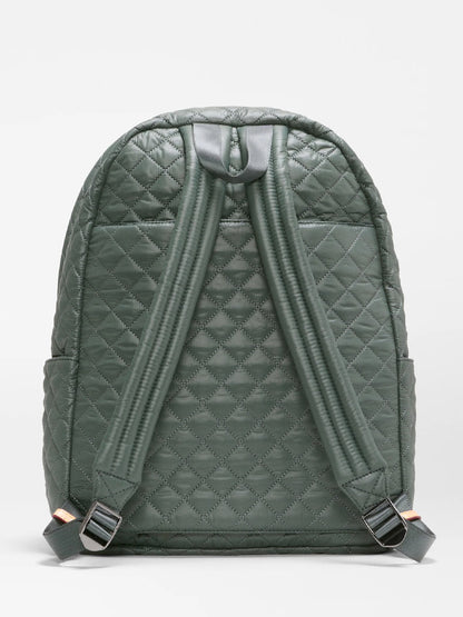 The MZ Wallace Metro Backpack II in Juniper Oxford is showcased from the back, highlighting its two padded shoulder straps and top handle against a plain backdrop. Crafted from recycled nylon, this versatile backpack is ideal for use as a travel laptop bag, whether for daily commutes or weekend adventures.
