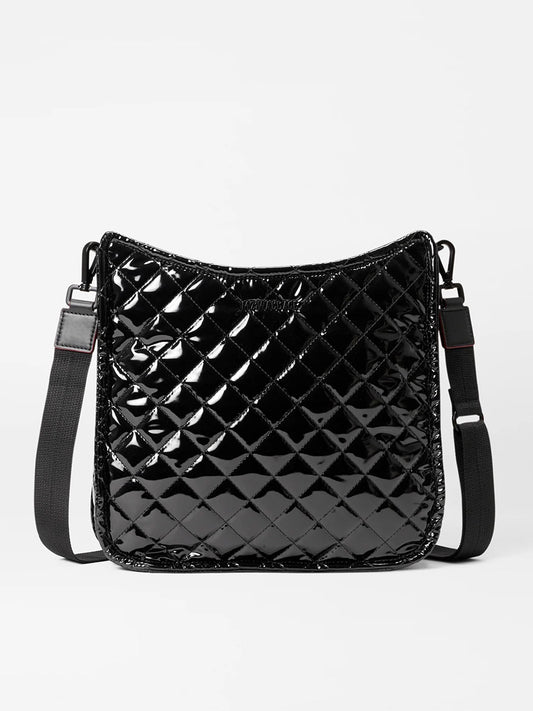 The MZ Wallace Metro Box Crossbody in Black Lacquer Oxford is showcased against a plain background, featuring a quilted patent leather design and an adjustable strap, embodying the chic elegance typical of designer crossbody bags.