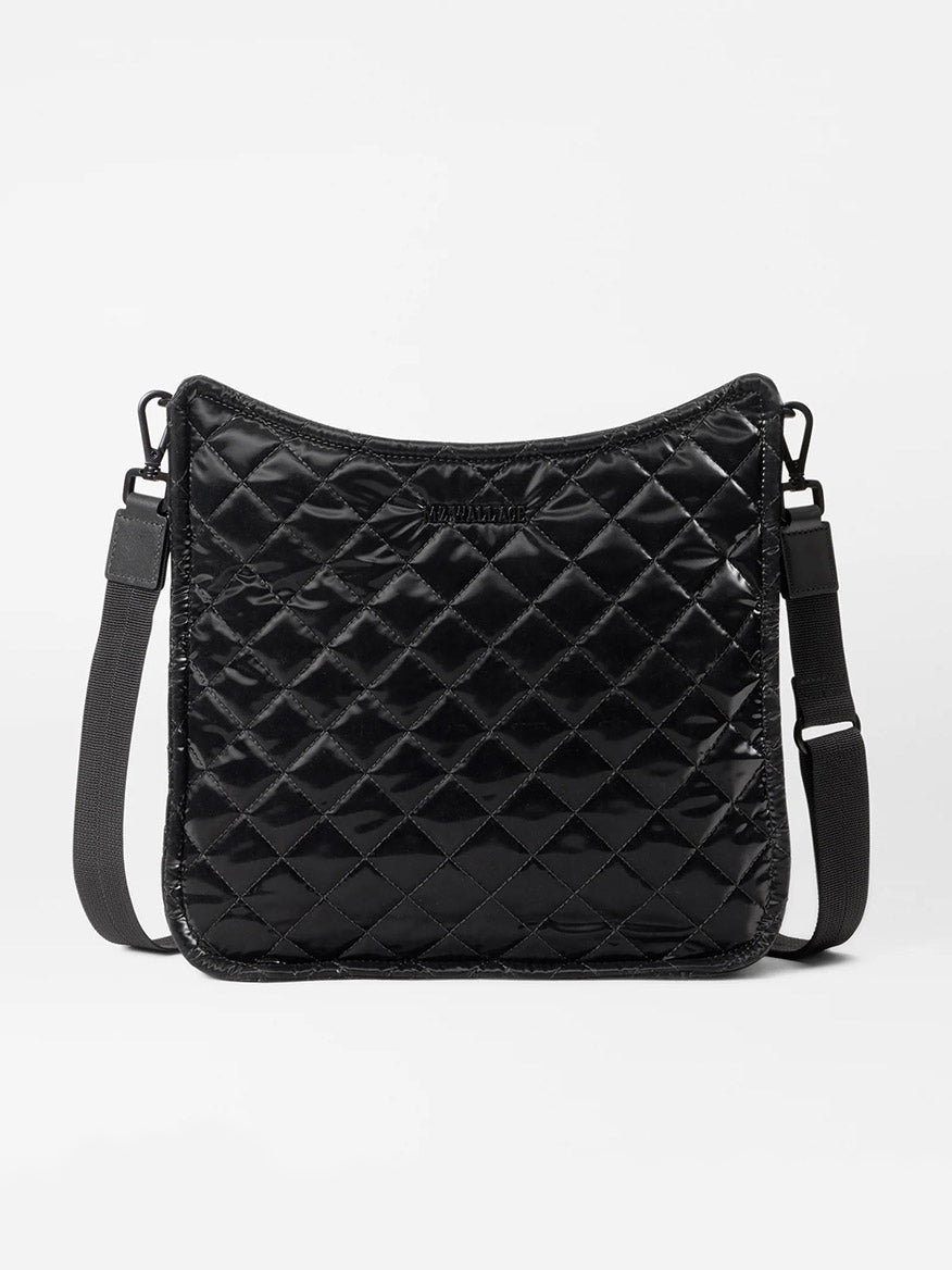 The MZ Wallace Metro Box Crossbody in Black Liquid Oxford, featuring adjustable straps and crafted from liquid nylon, rests elegantly on a plain background.