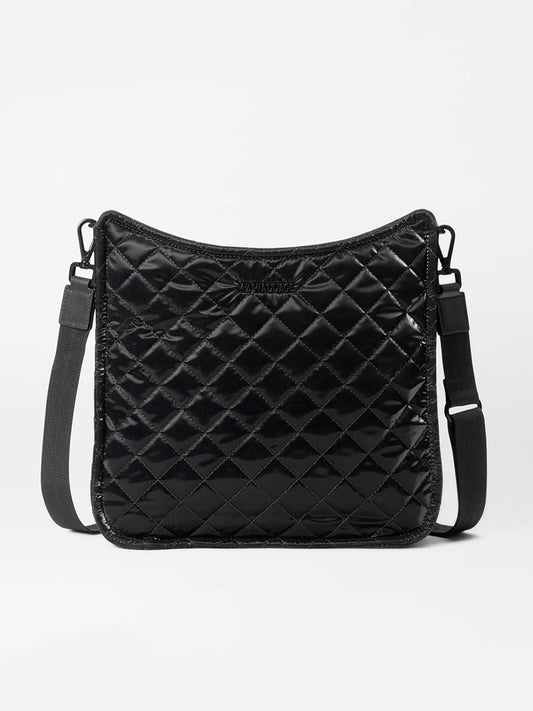 The MZ Wallace Metro Box Crossbody in Black Liquid Oxford, featuring adjustable straps and crafted from liquid nylon, rests elegantly on a plain background.