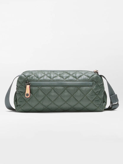The MZ Wallace Metro East West Crossbody in Juniper is a quilted dark green bag crafted from recycled nylon, featuring a front zip pocket, adjustable strap, and leather zipper pull, displayed against a plain light background—an ideal compact everyday bag.