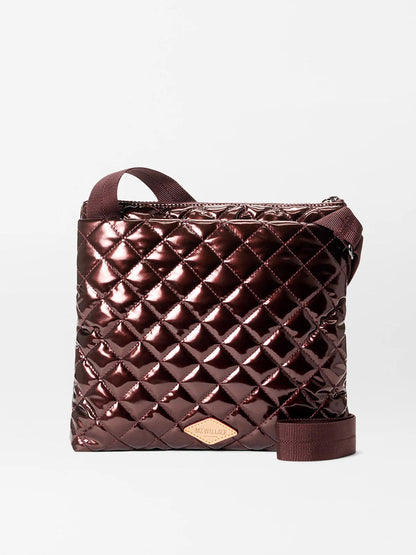 The MZ Wallace Metro Flat Crossbody in Bordeaux Lacquer Oxford features a shiny, quilted diamond pattern, adjustable strap, and front logo patch—making it a stylish, hands-free bag for any occasion.
