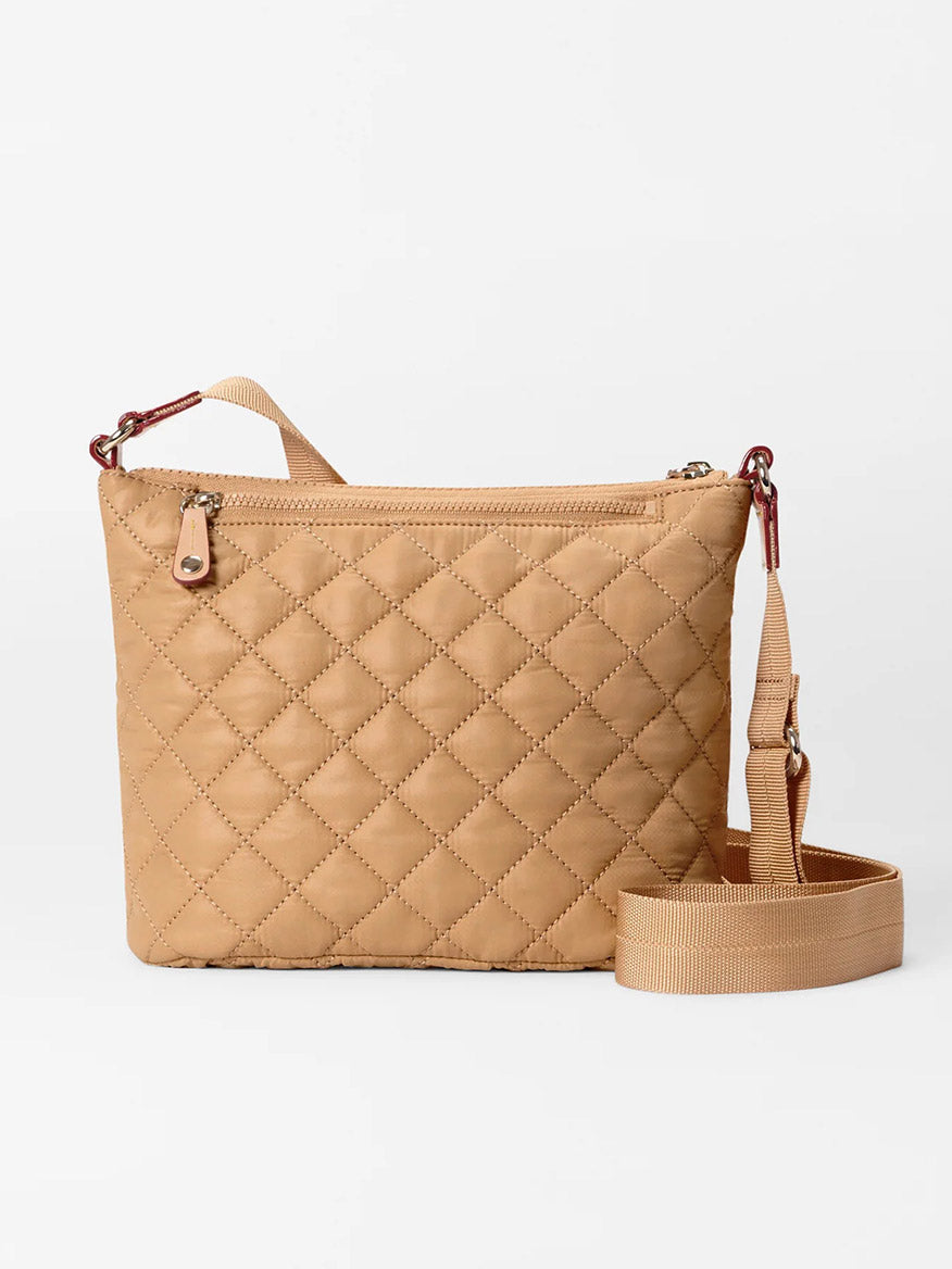 The MZ Wallace Metro Scout Deluxe in Caramel Oxford is a beige quilted crossbody bag made from luxurious Italian leather, featuring a zipper, adjustable strap, and small top carrying handle.