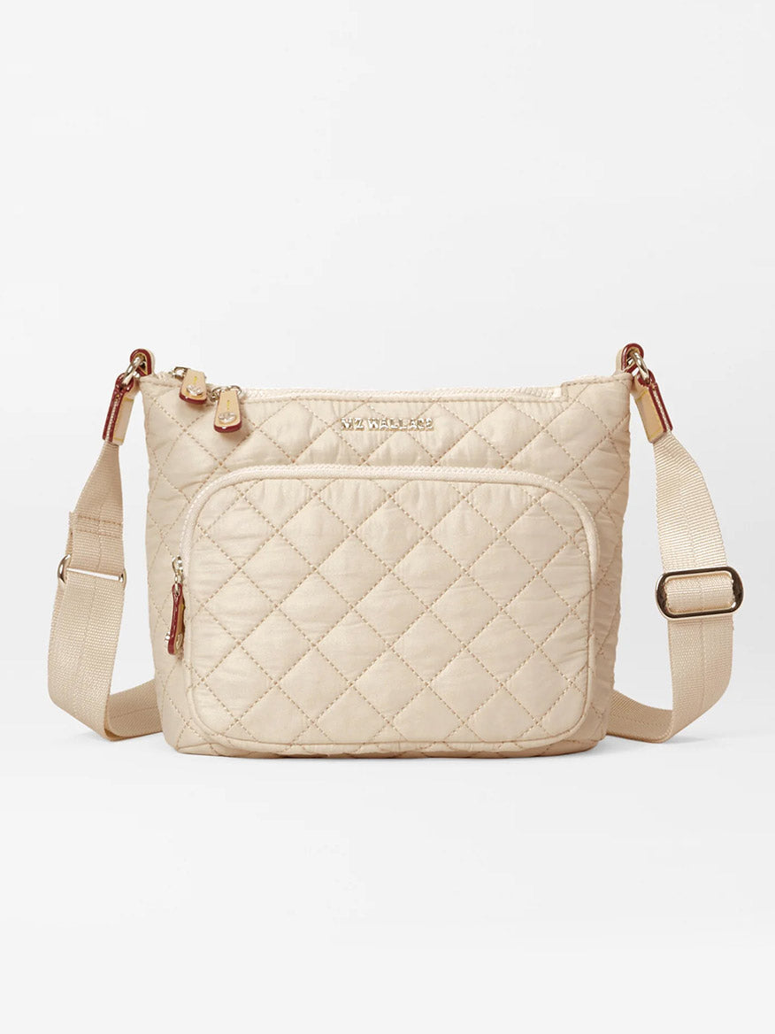 The MZ Wallace Metro Scout Deluxe in Buff Oxford is a quilted crossbody bag made from luxurious Italian leather, featuring an adjustable strap, a front zip pocket, and gold-tone hardware.